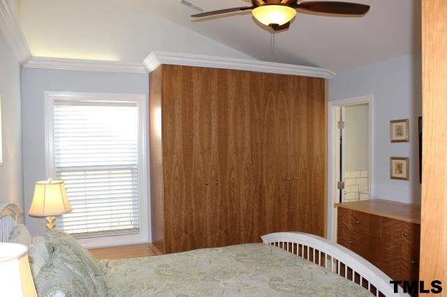 1045 Mills Street Raleigh, NC 27608 - Photo 12 of 20 a bedroom with a bed and a chandelier