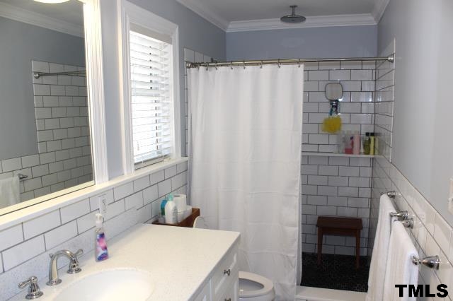 1045 Mills Street Raleigh, NC 27608 - Photo 13 of 20 a bathroom with a sink and a shower curtain