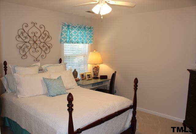 1045 Mills Street Raleigh, NC 27608 - Photo 16 of 20 a bedroom with a bed and a chandelier