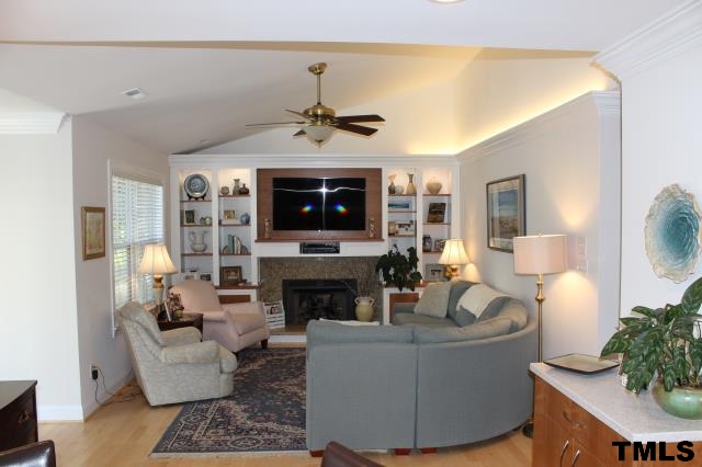 1045 Mills Street Raleigh, NC 27608 - Photo 3 of 20 a living room with furniture a fireplace and a flat screen tv