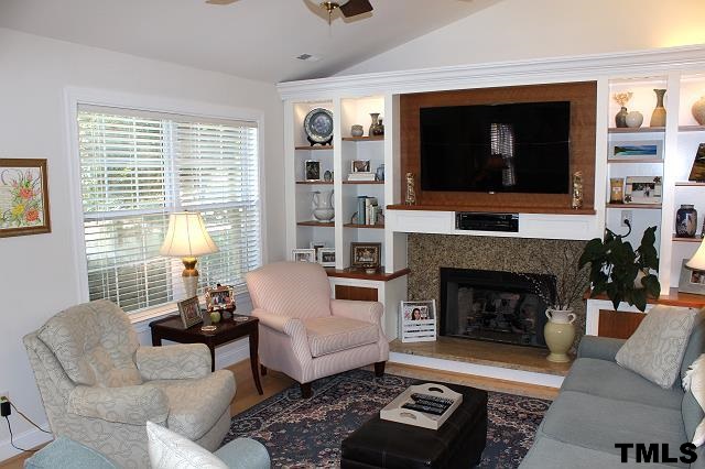 1045 Mills Street Raleigh, NC 27608 - Photo 4 of 20 a living room with furniture a flat screen tv and a fireplace