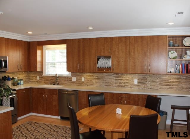 1045 Mills Street Raleigh, NC 27608 - Photo 6 of 20 a kitchen with a table chairs sink and cabinets