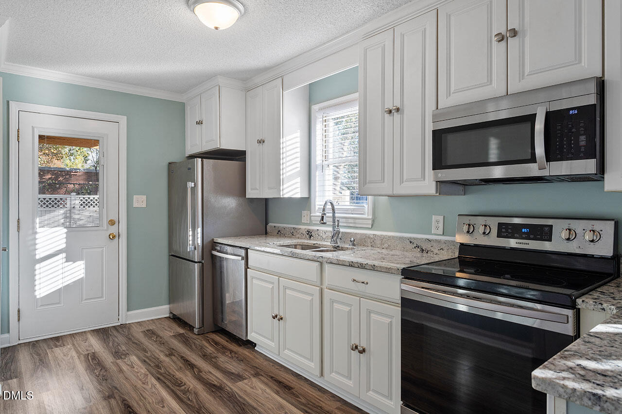2306 Stafford Avenue, Unit D Raleigh, NC 27607 - Photo 11 of 24 a kitchen with stainless steel appliances granite countertop a stove a refrigerator and a microwave