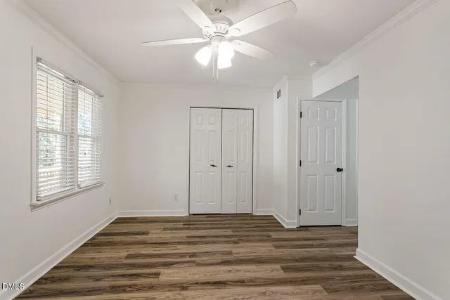 a view of a livingroom with wooden floor and a ceiling fan