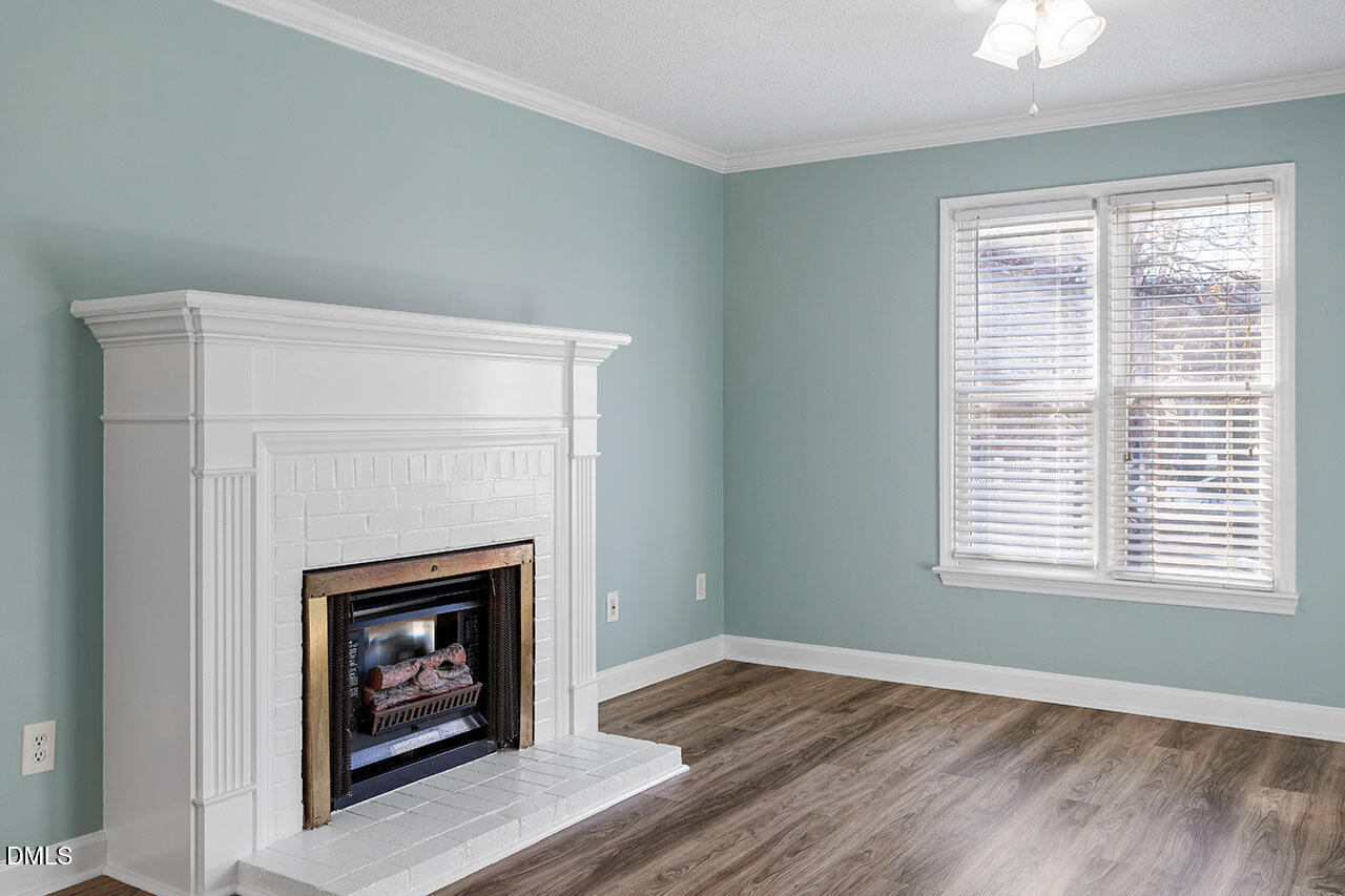 2306 Stafford Avenue, Unit D Raleigh, NC 27607 - Photo 3 of 24 a view of an empty room with wooden floor fireplace and a window