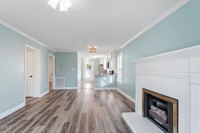 a view of a hallway with wooden floor and a fireplace