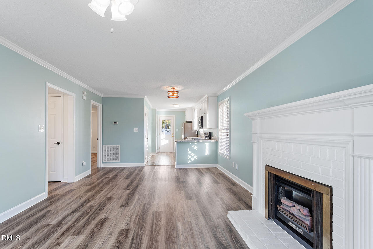 2306 Stafford Avenue, Unit D Raleigh, NC 27607 - Photo 6 of 24 a view of a hallway with wooden floor and a fireplace