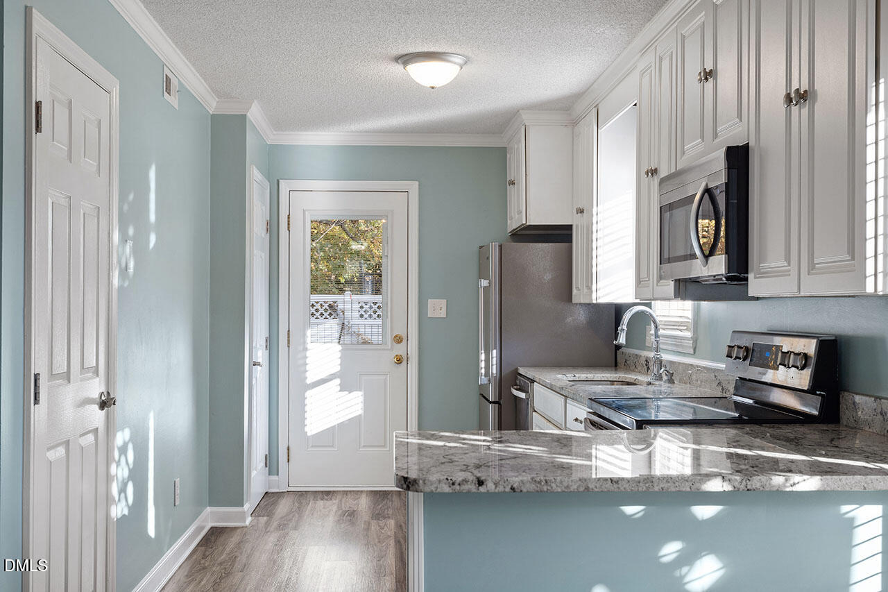 2306 Stafford Avenue, Unit D Raleigh, NC 27607 - Photo 9 of 24 a kitchen with stainless steel appliances granite countertop a refrigerator and a sink