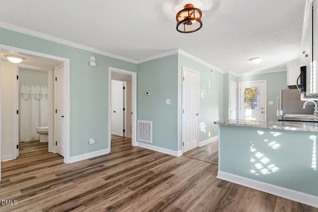 a view of a kitchen with wooden floor and a window
