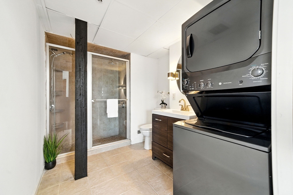 210 Broadway, Unit 406 Everett, MA 02149 - Photo 13 of 33 a kitchen with stainless steel appliances a stove a refrigerator and a glass door