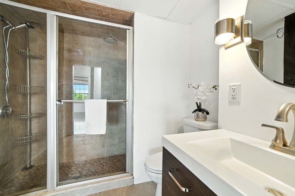 210 Broadway, Unit 406 Everett, MA 02149 - Photo 16 of 33 a bathroom with a sink vanity mirror and shower