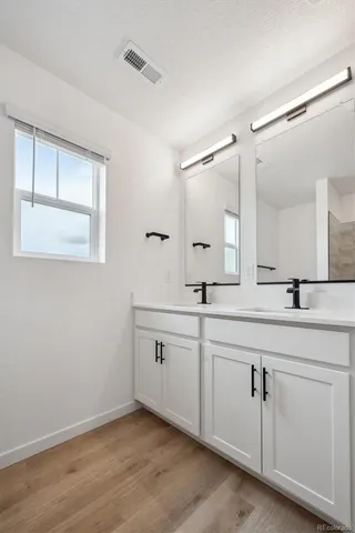 a bathroom with a double vanity sink and a mirror