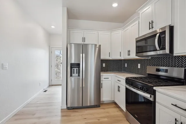 a kitchen with stainless steel appliances a refrigerator stove and microwave