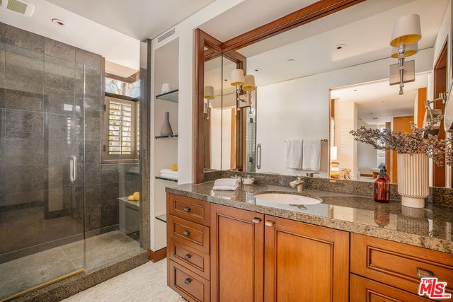 a bathroom with double vanity sinks and a shower