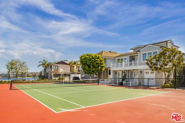 a view of a tennis ground with large trees