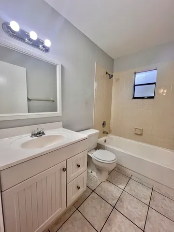 a bathroom with a double vanity sink toilet mirror and bathtub