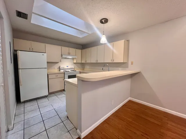 a kitchen with a sink a cabinetry and refrigerator