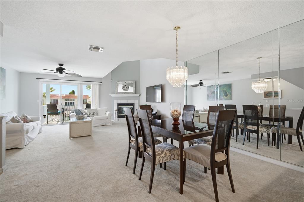 643 Garland Circle Indian Rocks Beach, FL 33785 - Photo 19 of 81 a view of a dining room and livingroom with furniture wooden floor a rug a painting and a chandelier