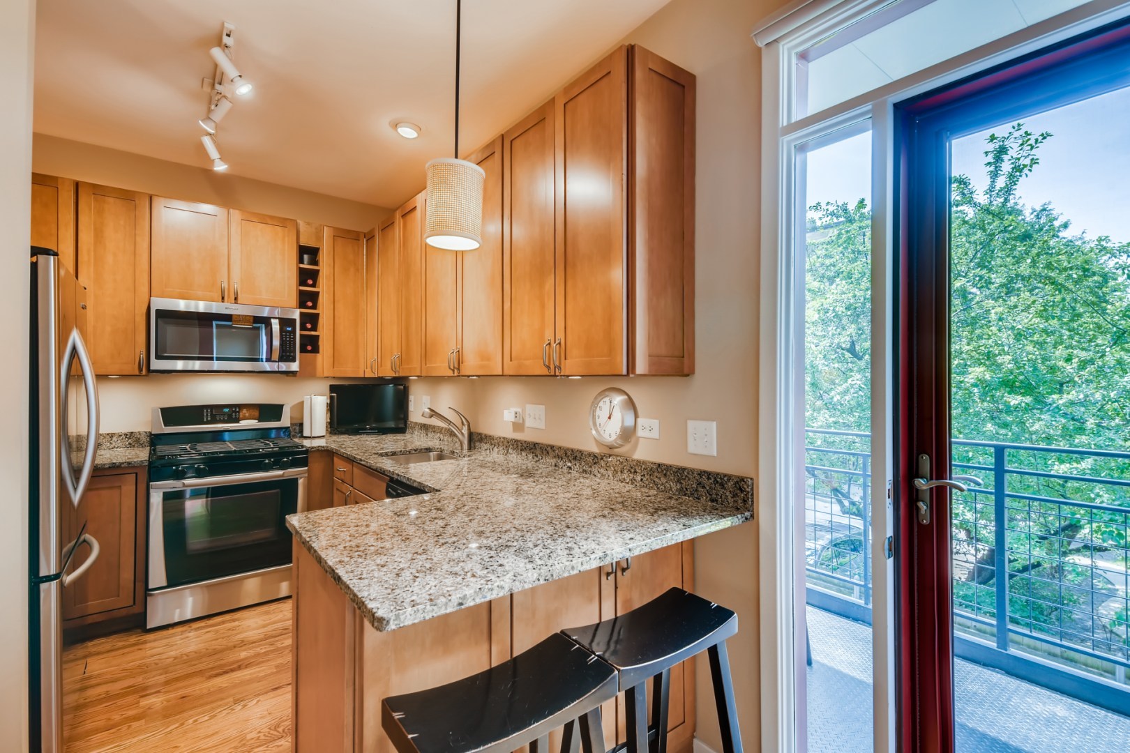 1244 West Monroe Street, Unit 5 Chicago, IL 60607 - Photo 8 of 21 a kitchen with stainless steel appliances granite countertop hardwood floor sink stove and refrigerator