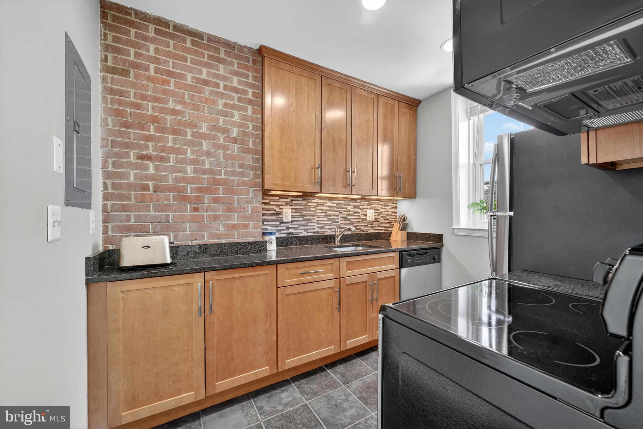 2001 16th Street Northwest, Unit 307 Washington, DC 20009 - Photo 8 of 27 a kitchen with stainless steel appliances granite countertop a sink and cabinets