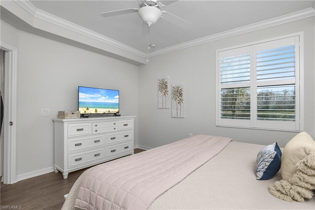 9560 Trevi Court, Unit 4811 Naples, FL 34113 - Photo 12 of 40 a bedroom with a bed and a flat screen tv