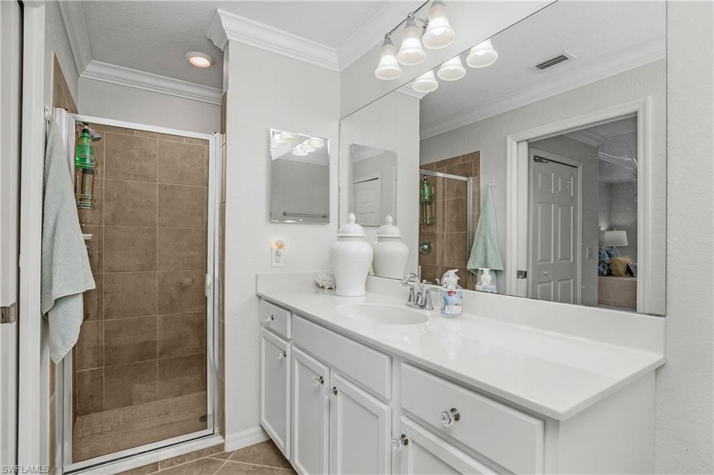 9560 Trevi Court, Unit 4811 Naples, FL 34113 - Photo 13 of 40 a bathroom with a double vanity sink mirror and shower
