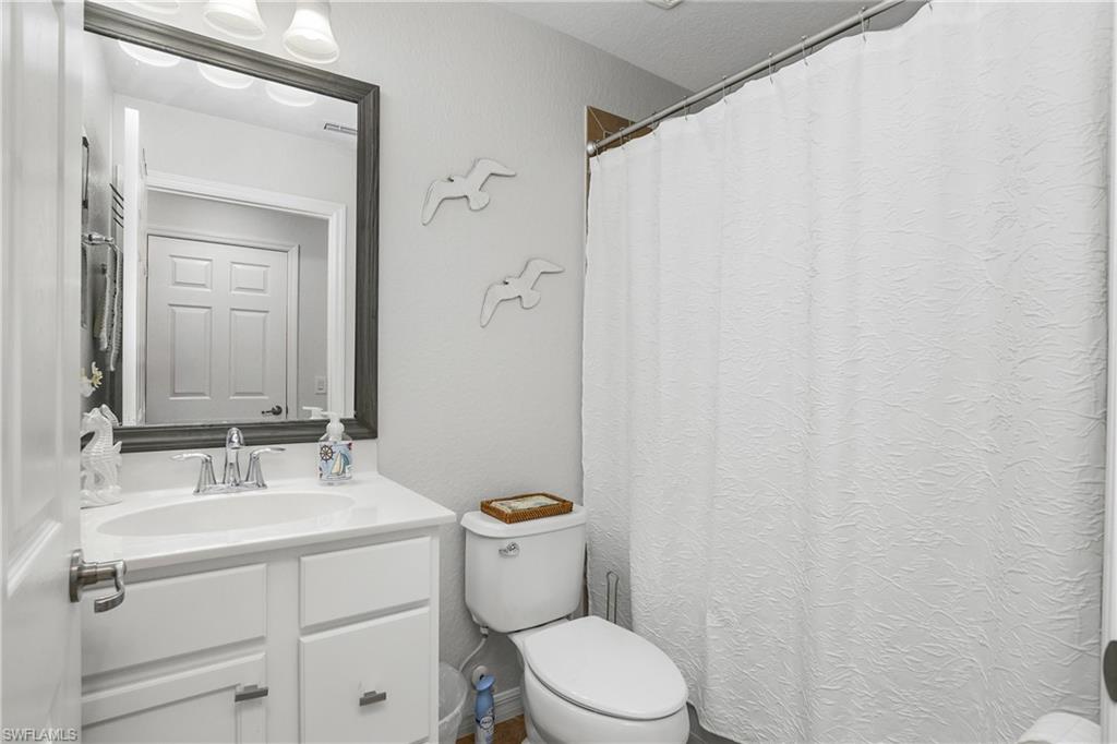 9560 Trevi Court, Unit 4811 Naples, FL 34113 - Photo 15 of 40 a bathroom with a sink mirror vanity and toilet