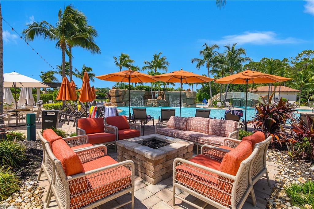 9560 Trevi Court, Unit 4811 Naples, FL 34113 - Photo 30 of 40 a view of a patio with a table and chairs under an umbrella