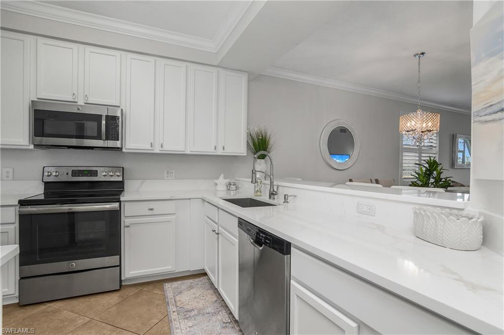 9560 Trevi Court, Unit 4811 Naples, FL 34113 - Photo 7 of 40 a kitchen with a sink and a microwave