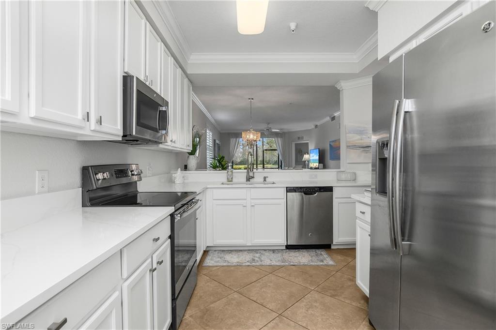 9560 Trevi Court, Unit 4811 Naples, FL 34113 - Photo 9 of 40 a kitchen with stainless steel appliances granite countertop a refrigerator sink and stove