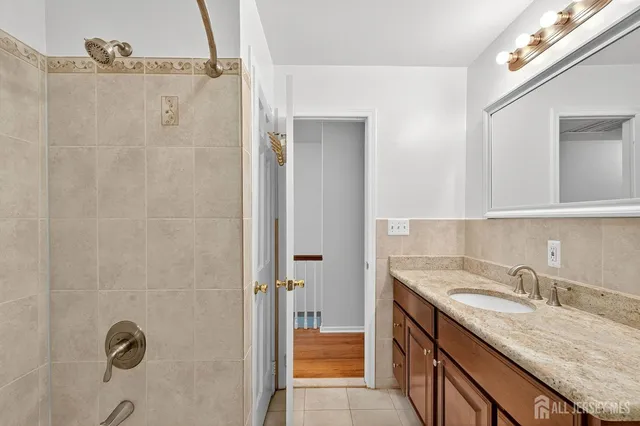 a bathroom with a granite countertop sink toilet and mirror