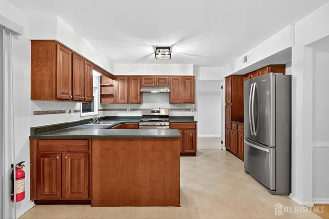 a kitchen with stainless steel appliances granite countertop a refrigerator and a stove top oven