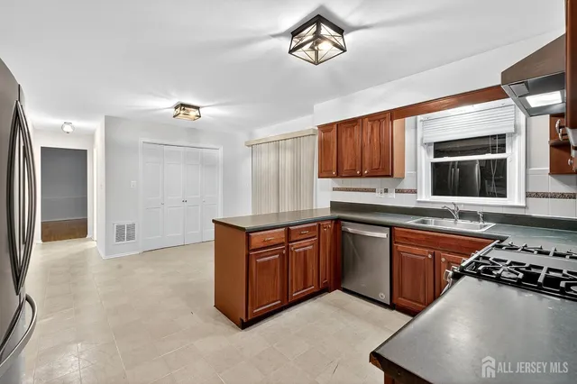 a kitchen with stainless steel appliances granite countertop a stove a sink and a refrigerator