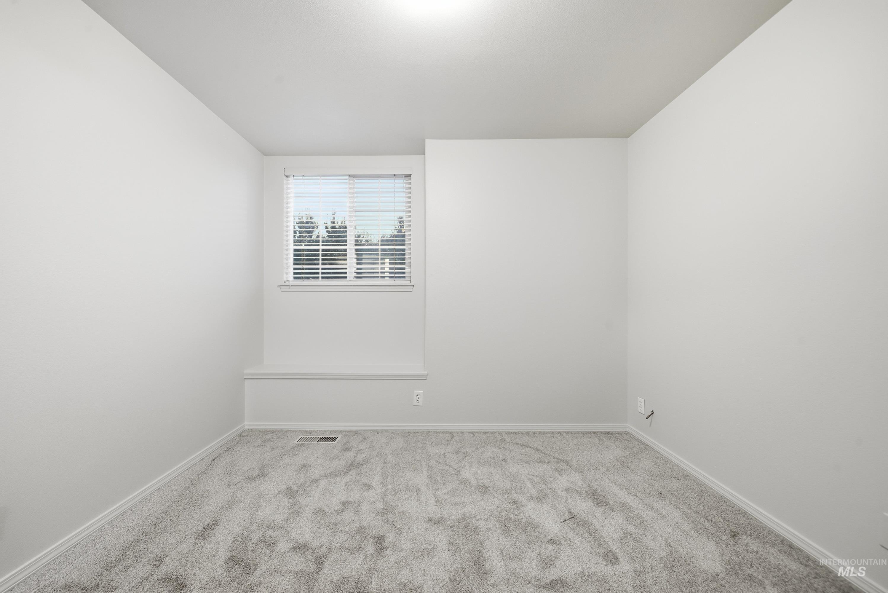 919 East Hawk Street Meridian, ID 83646 - Photo 16 of 31 Neutral wall paint, light-colored carpeting, and a window with horizontal blinds