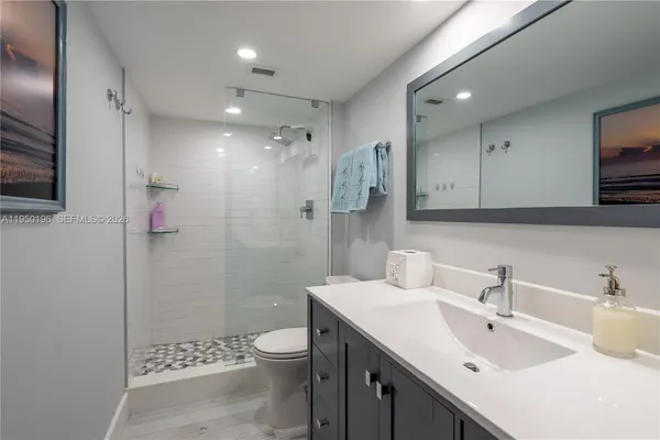 a bathroom with a sink a toilet and shower