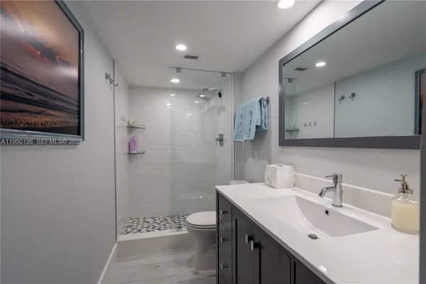 a bathroom with a sink a toilet and shower