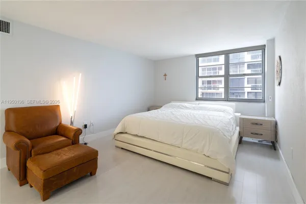 a bedroom with bed couch and window