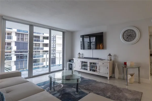 a living room with furniture and a floor to ceiling window