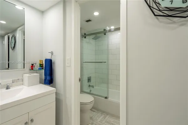 a bathroom with a shower sink vanity mirror and toilet