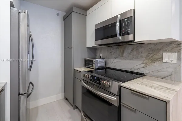 a kitchen with stainless steel appliances granite countertop a stove microwave and refrigerator