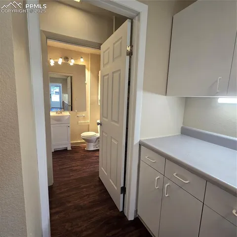 a view of a hallway with bathroom and wooden floor