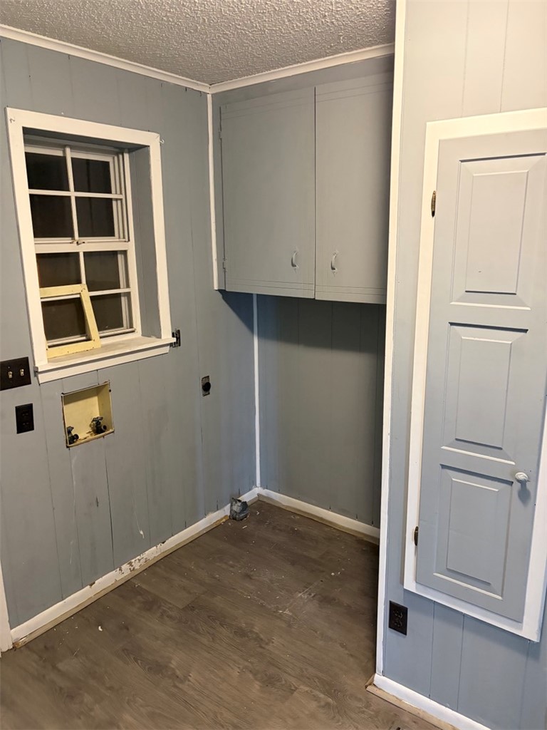 618 Madden Road Jacksonville, AR 72076 - Photo 14 of 34 Utility area featuring wood-finish flooring, light blue paneling, white trim, a built-in wall cabinet, and a window