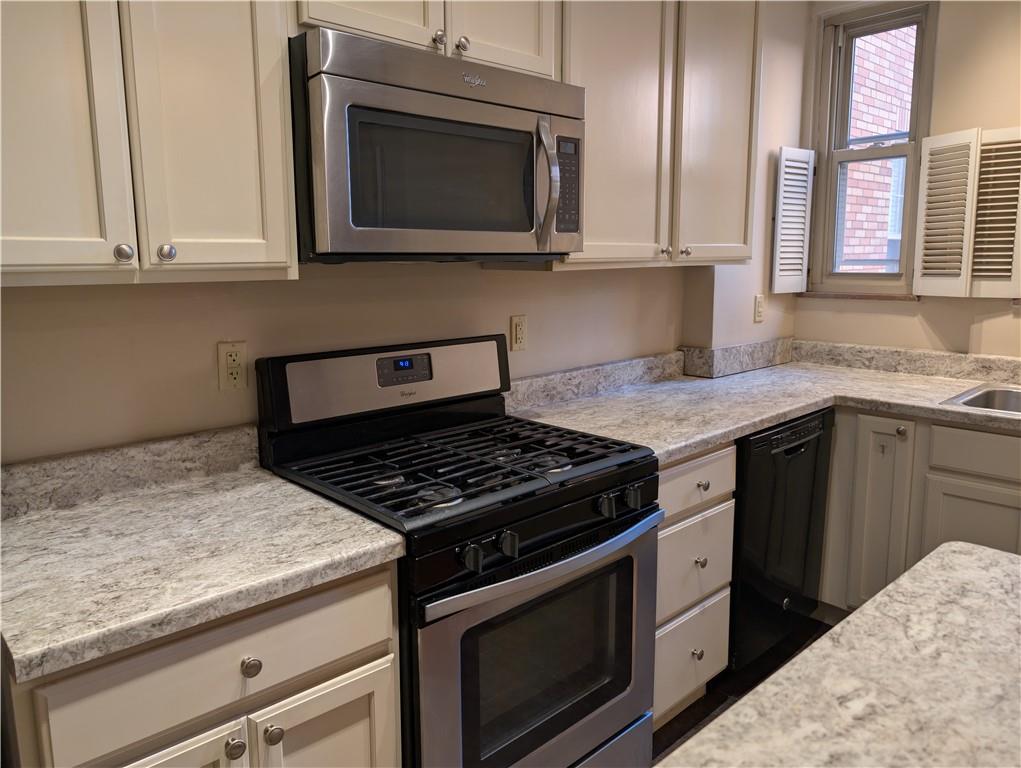 144 North Dithridge Street, Unit 403 Pittsburgh, PA 15213 - Photo 4 of 31 a kitchen with granite countertop a stove top oven microwave and cabinets
