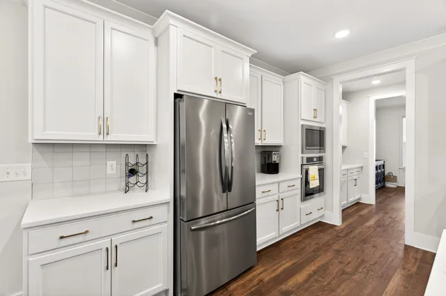 a kitchen with stainless steel appliances kitchen island granite countertop a sink and a refrigerator
