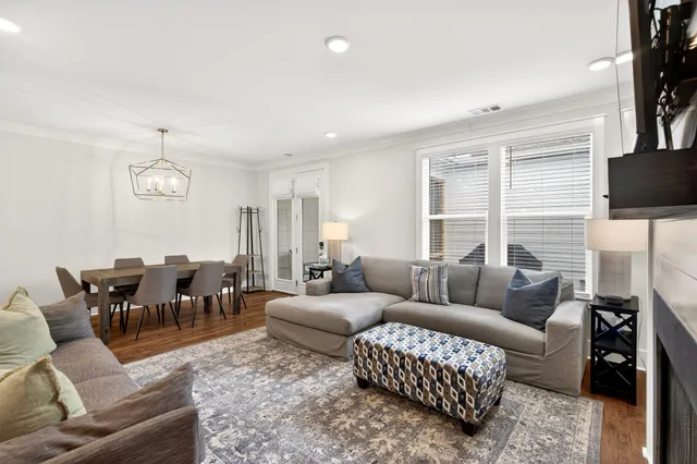 a living room with furniture kitchen view and a chandelier