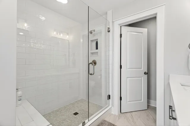 a kitchen with stainless steel appliances a sink a stove a refrigerator cabinets and a kitchen island