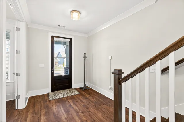 a view of a hallway with wooden floor and staircase