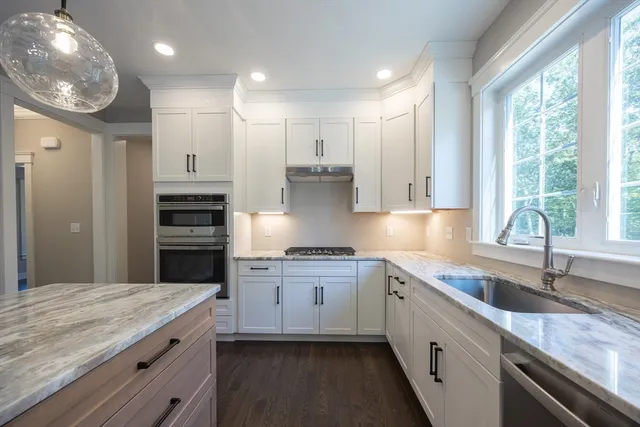 a kitchen with a sink stainless steel appliances and window