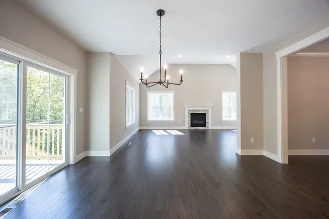 a view of a room with wooden floor fireplace and windows
