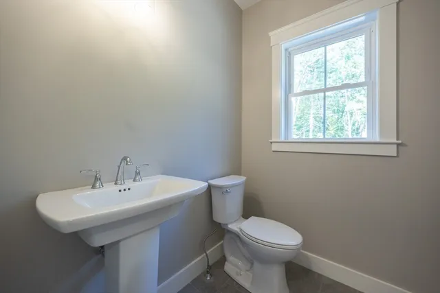 a bathroom with a sink a toilet and a window